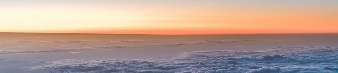 Sonnenuntergang über dem Meer mit sanften Wellen und pastellfarbenem Himmel. Ausblick in eine friedliche Zukunft.